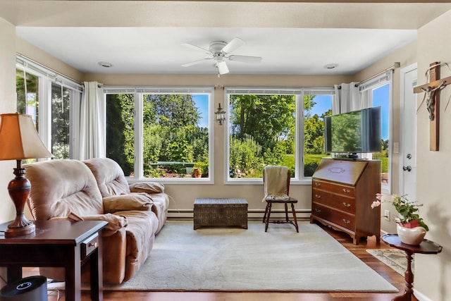 sunroom featuring ceiling fan, plenty of natural light, and baseboard heating