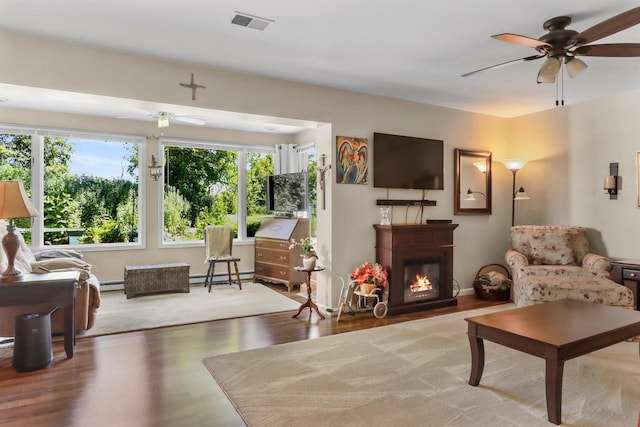 sitting room with a baseboard radiator, hardwood / wood-style floors, and ceiling fan