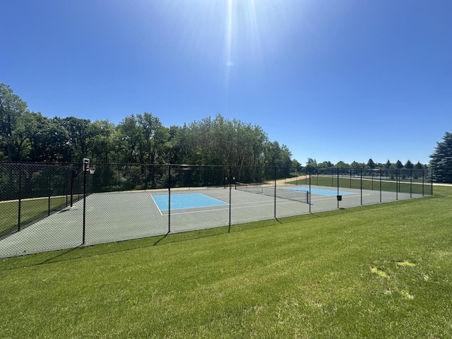 view of tennis court with a lawn