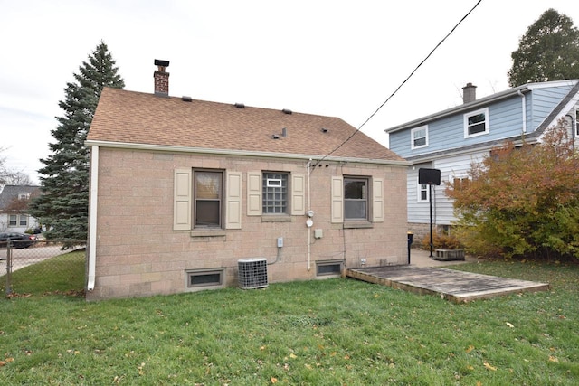 back of property featuring a lawn and central air condition unit