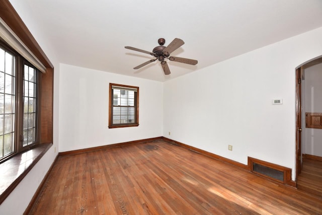 spare room featuring hardwood / wood-style floors, a wealth of natural light, and ceiling fan