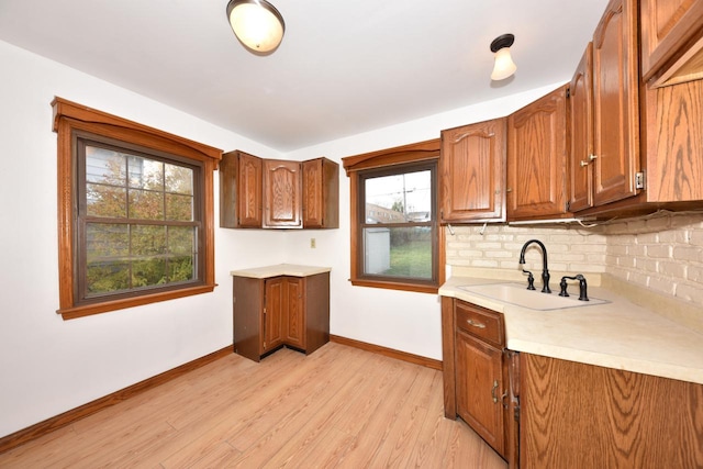 kitchen featuring sink, light hardwood / wood-style flooring, and decorative backsplash