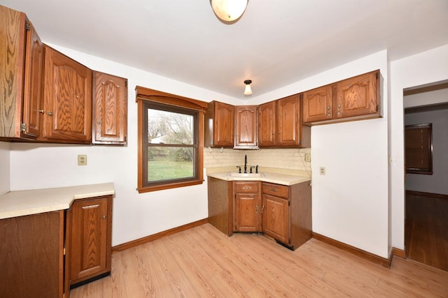 kitchen with light hardwood / wood-style floors, sink, and backsplash