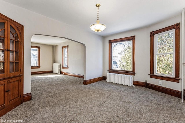 empty room with radiator and carpet flooring