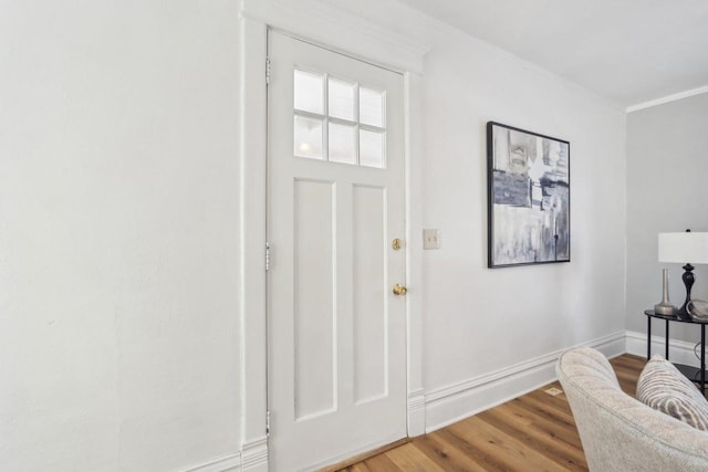 entrance foyer featuring crown molding, baseboards, and wood finished floors