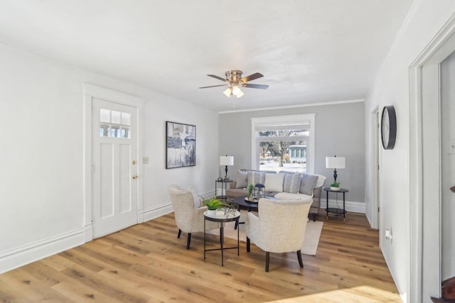 sitting room with light wood finished floors, a ceiling fan, and baseboards