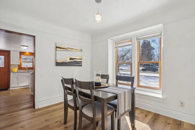 dining space with wood finished floors and baseboards