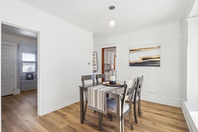 dining room with baseboards, wood finished floors, and ornamental molding