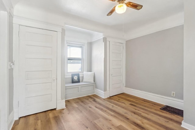 unfurnished bedroom with a ceiling fan, light wood-type flooring, visible vents, and baseboards