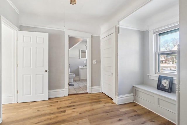 interior space featuring crown molding, baseboards, and wood finished floors