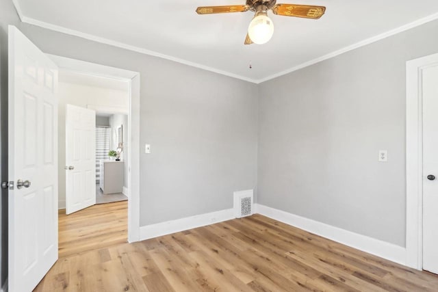 unfurnished room with light wood finished floors, baseboards, visible vents, a ceiling fan, and ornamental molding