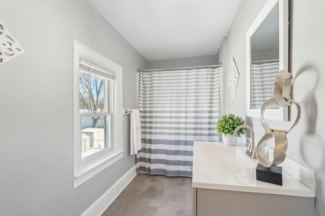 full bathroom with vanity and baseboards