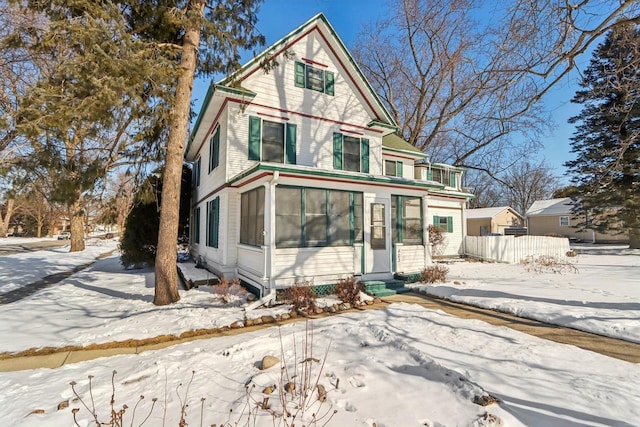 victorian-style house with entry steps and fence