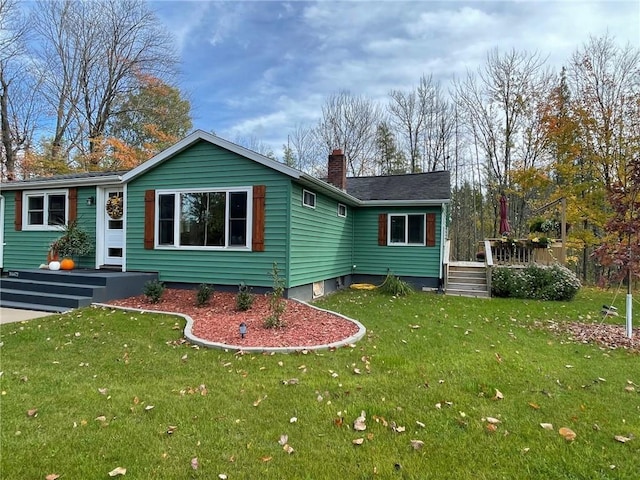 view of front of home with a chimney and a front lawn