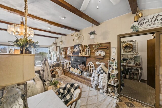 living room featuring beam ceiling and ceiling fan with notable chandelier