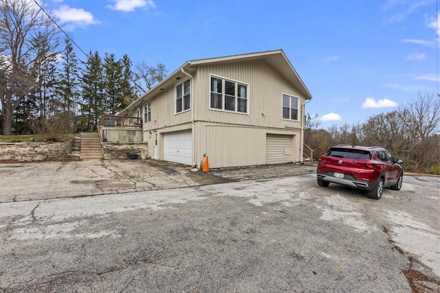 view of side of property with a wooden deck and a garage