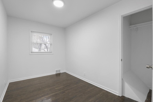 unfurnished bedroom featuring dark hardwood / wood-style flooring and a closet