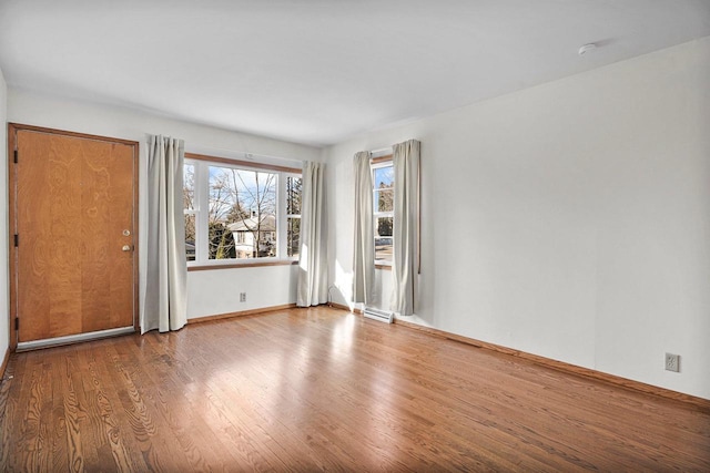 empty room featuring visible vents, baseboards, and wood finished floors