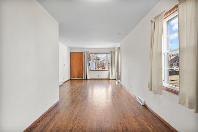 spare room featuring wood finished floors, visible vents, and baseboards