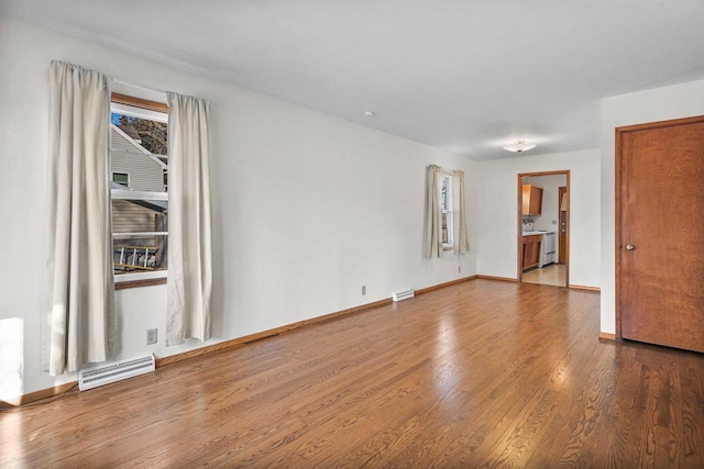 unfurnished room with visible vents, baseboards, and wood finished floors