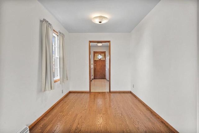 unfurnished room featuring light wood finished floors and baseboards