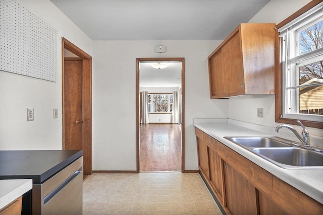 kitchen with a sink, brown cabinets, and light countertops