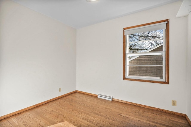 spare room featuring light wood-style flooring, baseboards, and visible vents