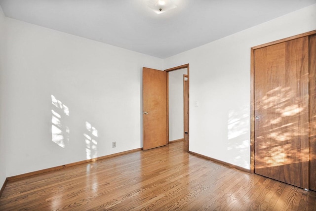 unfurnished bedroom with baseboards and wood finished floors