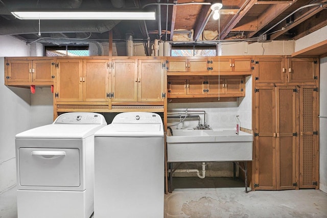 clothes washing area featuring a sink, cabinet space, and washing machine and dryer