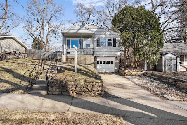 view of front of house featuring a storage unit, an outbuilding, driveway, fence, and an attached garage