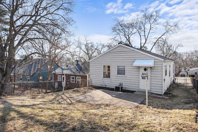 rear view of house with central AC unit, a fenced backyard, and a chimney