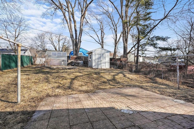 view of yard with an outbuilding, a shed, an exterior structure, and a fenced backyard