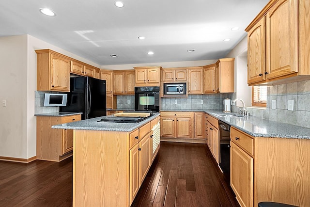 kitchen with dark wood-type flooring, sink, light stone counters, a center island, and black appliances