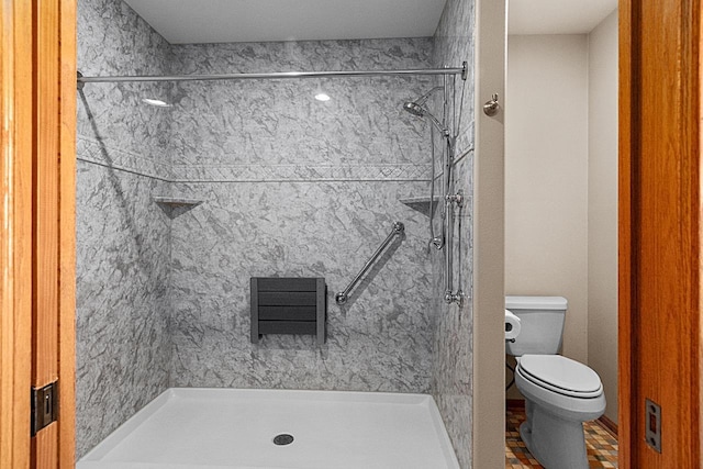 bathroom with tiled shower and toilet