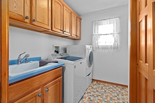 laundry room featuring cabinets, sink, and independent washer and dryer