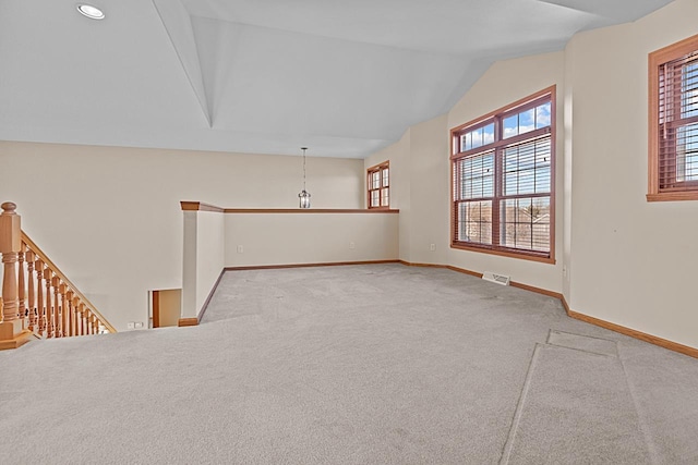 spare room with vaulted ceiling and light carpet