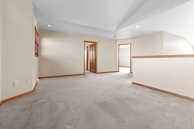 unfurnished room featuring light colored carpet and vaulted ceiling