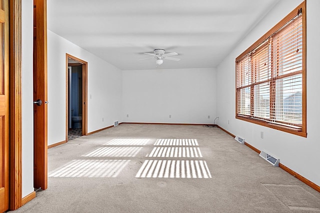 spare room with light colored carpet and ceiling fan