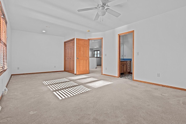 unfurnished bedroom with light carpet, a closet, ceiling fan, and ensuite bathroom