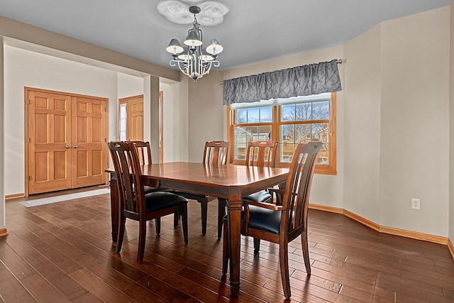 dining area featuring dark wood-type flooring and a notable chandelier