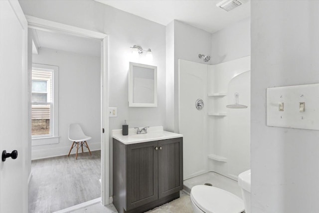 bathroom with walk in shower, vanity, toilet, and hardwood / wood-style flooring