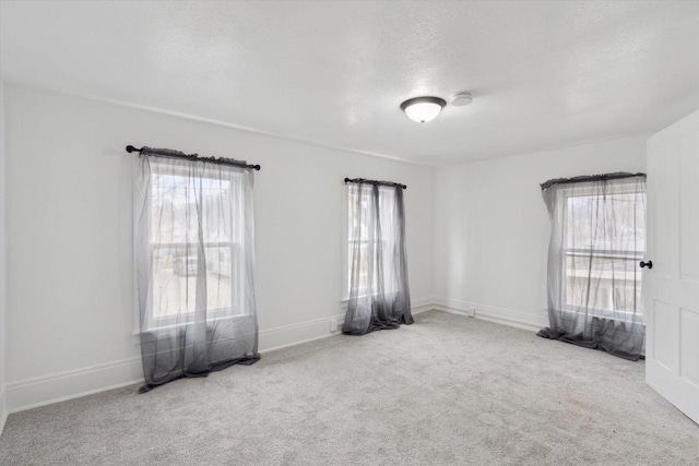 carpeted empty room featuring a textured ceiling