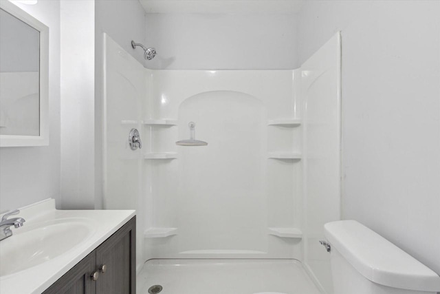 bathroom with vanity, toilet, and a shower