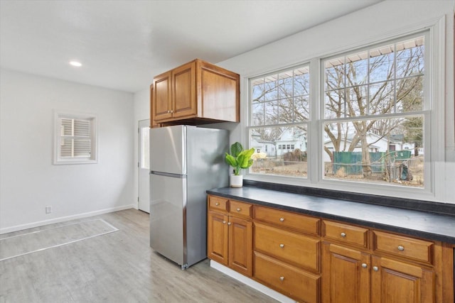 kitchen with stainless steel fridge and light hardwood / wood-style flooring