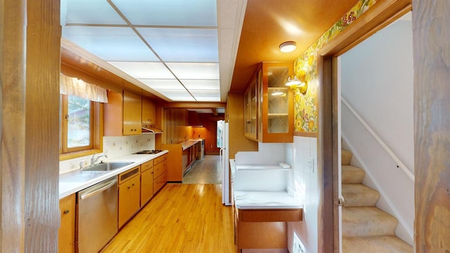 kitchen with sink, tasteful backsplash, light hardwood / wood-style flooring, gas cooktop, and dishwasher