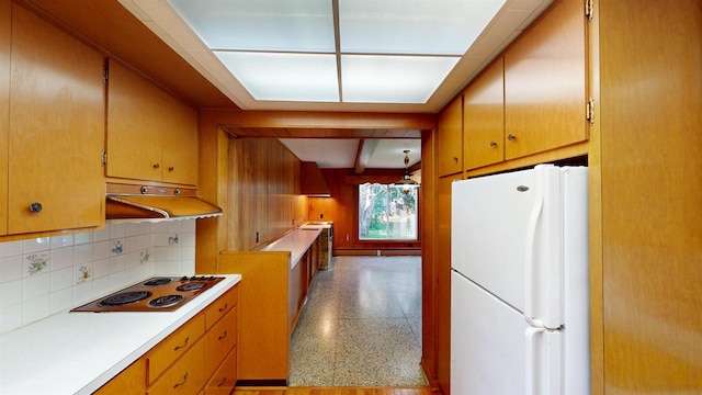 kitchen featuring white refrigerator, beam ceiling, stovetop, and tasteful backsplash