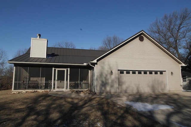 exterior space with a garage and a sunroom