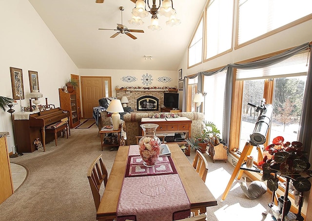 W5698 Losinski Rd, Princeton, WI 54968 - dining area with light colored carpet, ceiling fan, high vaulted ceiling, a brick fireplace, and a chandelier