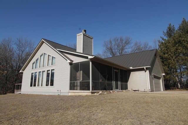 W5698 Losinski Rd, Princeton, WI 54968 - rear view of house featuring a chimney, a garage, a sunroom, and metal roof