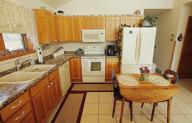 W5698 Losinski Rd, Princeton, WI 54968 - kitchen featuring white appliances, a sink, tasteful backsplash, light tile patterned floors, and vaulted ceiling
